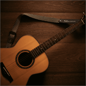 Acoustic guitar with strap available for pawn or sale at Ideal Jewelry and Loan pawn shop.