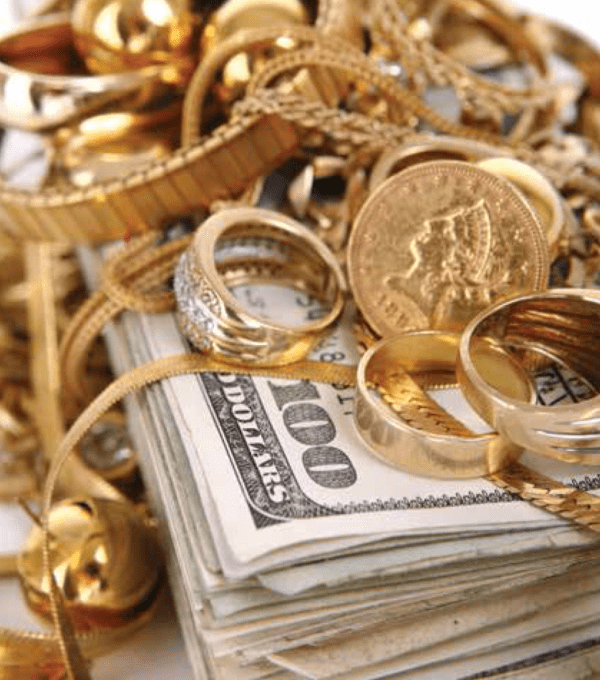 Gold jewelry and coins on cash stack at Ideal Jewelry and Loan pawn shop in Brockton, MA.