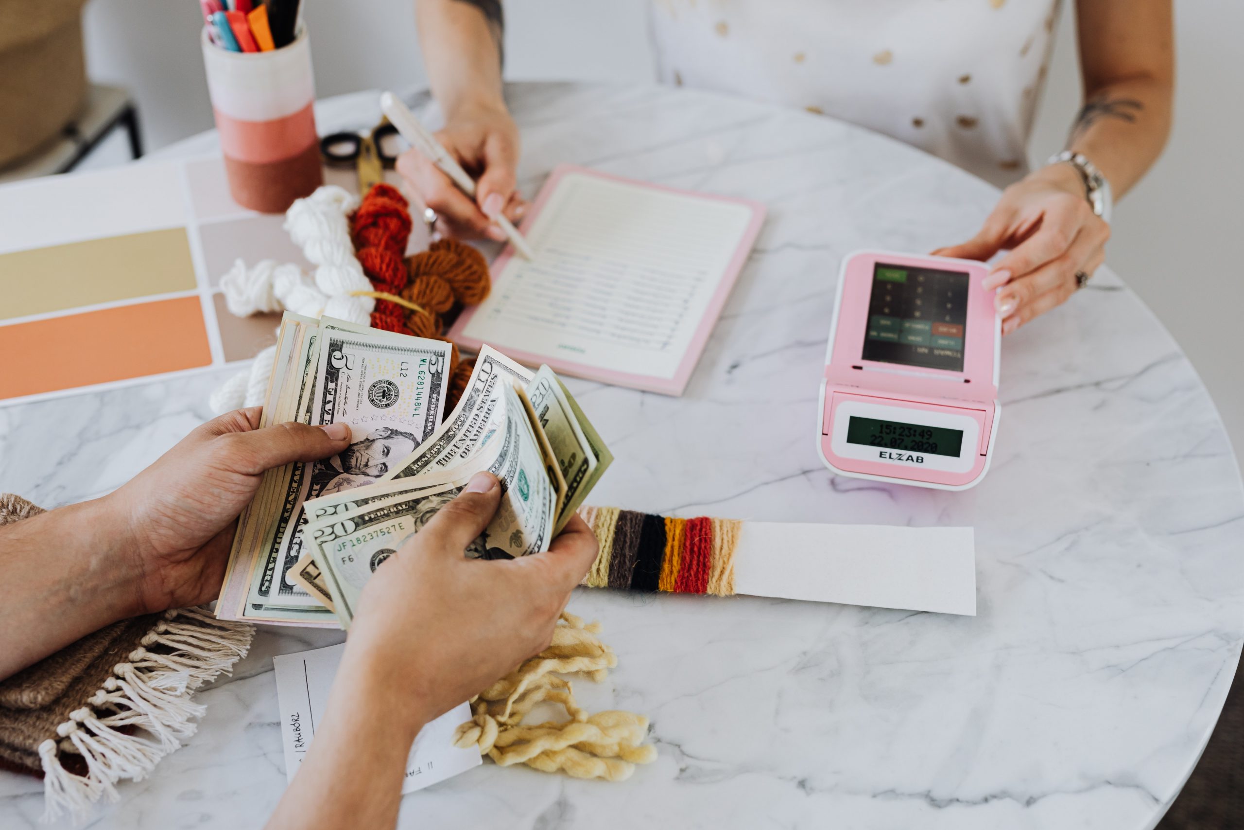 Customer counting cash after selling items at Ideal Jewelry and Loan pawn shop