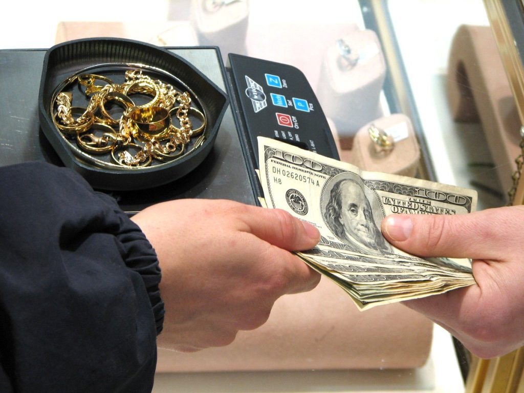 Customer receiving instant cash for gold jewelry at a pawn shop