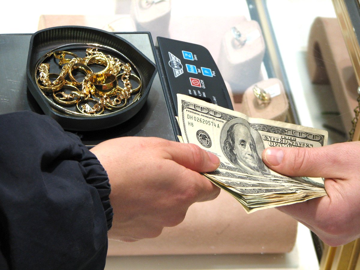 Customer receiving instant cash for gold jewelry at a pawn shop