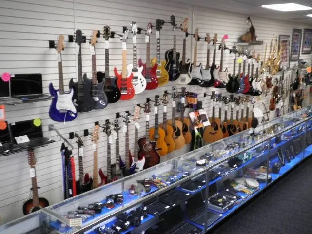 Wall display of electric and acoustic guitars inside a musical instrument pawnshop