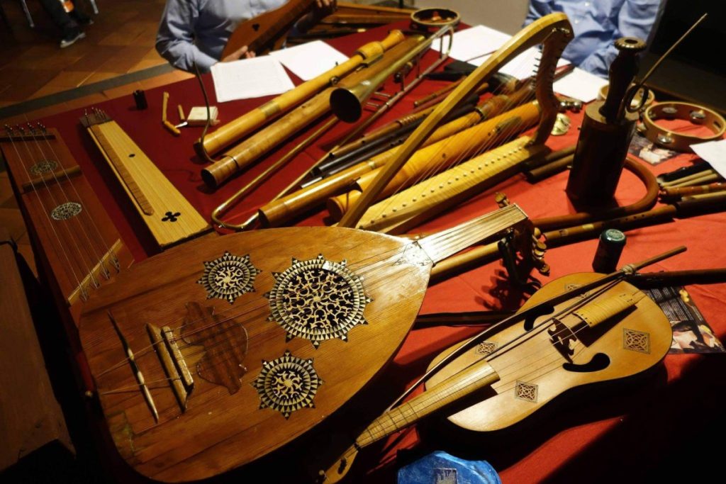 Various antique wooden musical instruments displayed on a red cloth