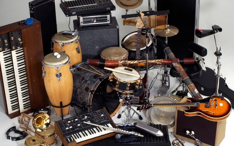 Guitar and keyboard with dollar bills on a wooden table
