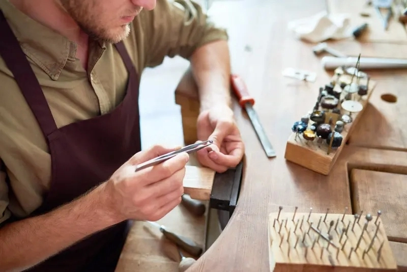 Jeweler inspecting a ring at a wooden workbench