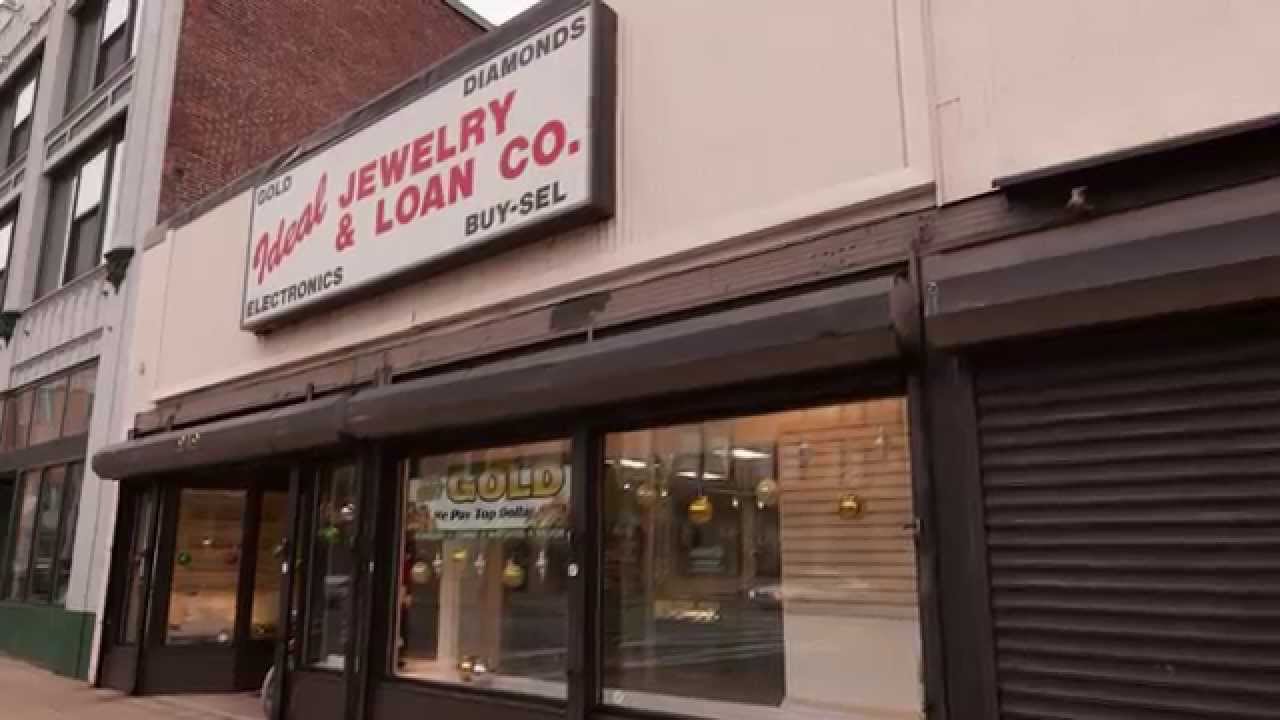 Modern pawnshop display with electronics, tools, and designer bags