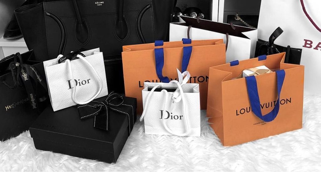 Designer bags and accessories displayed in a well-lit pawn shop case