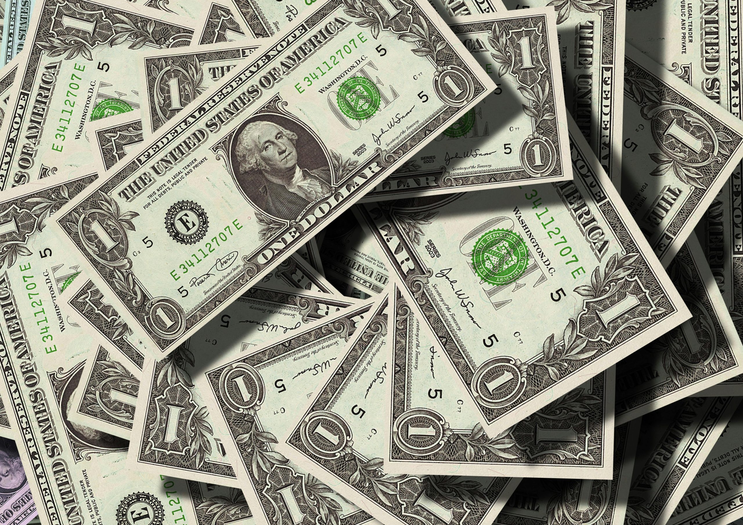 One-dollar bills scattered in a pile.