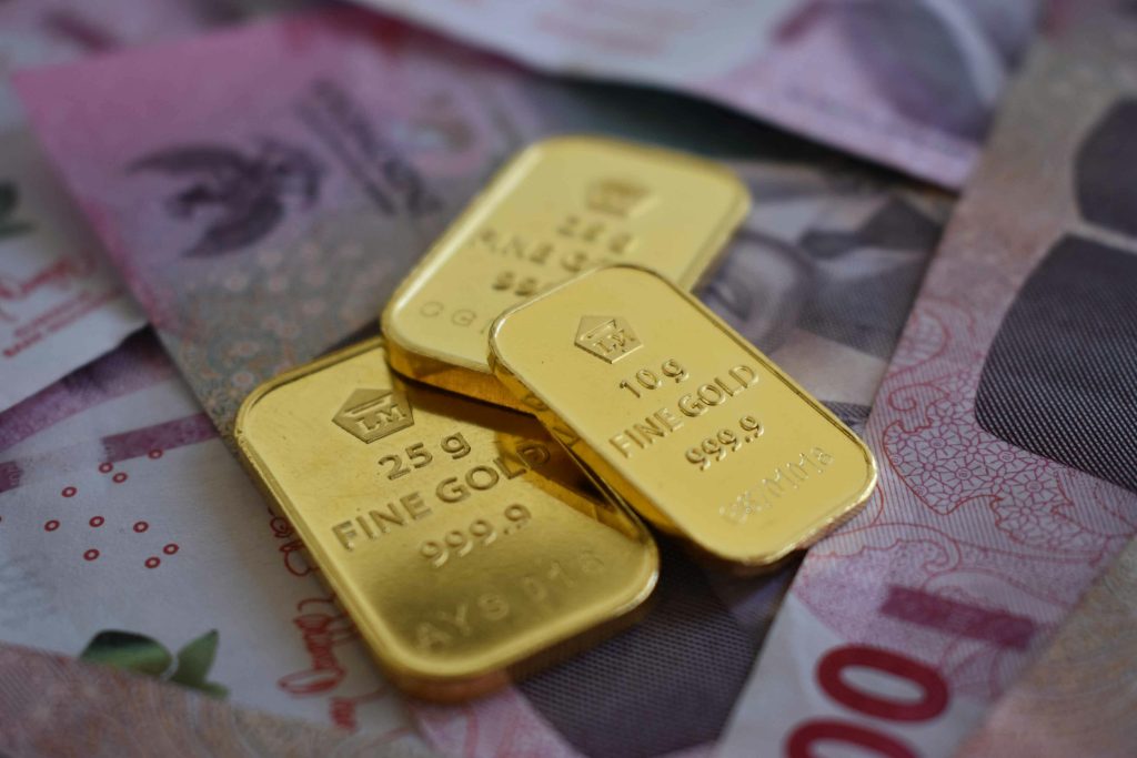 Gold bars placed on top of currency notes representing cash for gold transaction