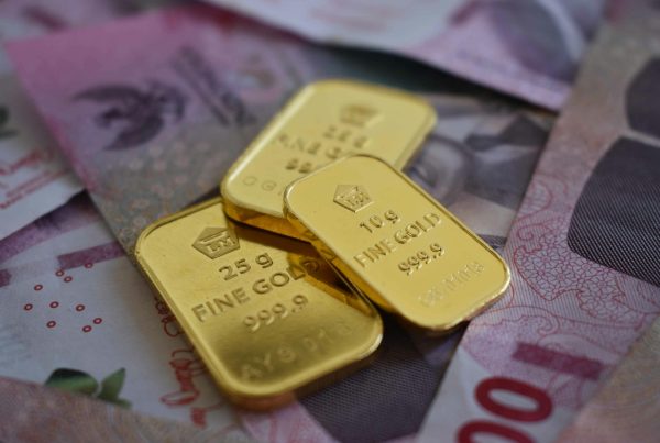 Gold bars placed on top of currency notes representing cash for gold transaction