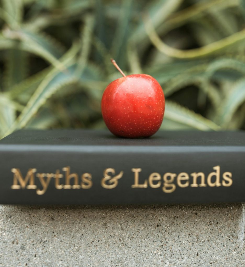 A red apple resting on a book titled "Myths & Legends," symbolizing common misconceptions about pawn shops