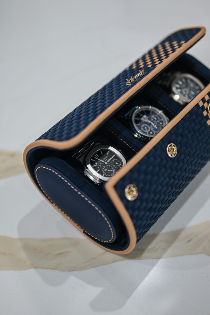 Close-up of luxury watches in a blue and tan leather case, showcasing premium timepieces considered for pawning or selling