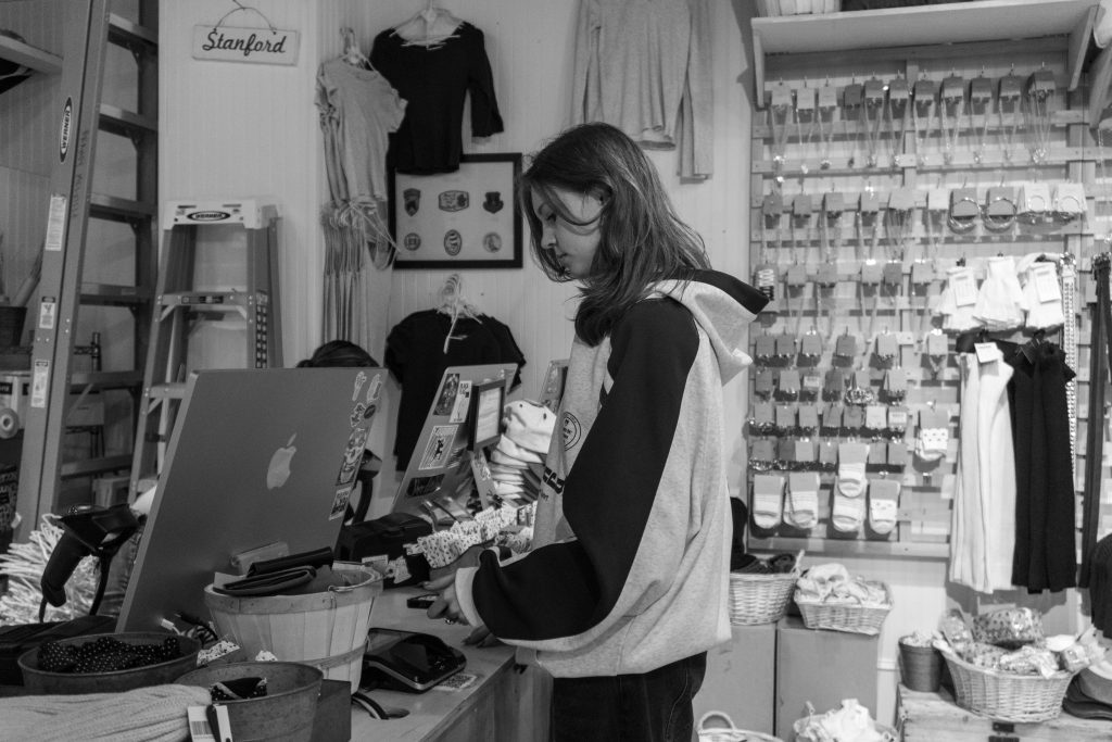 Young shopper browsing accessories at a pawn or thrift shop counter