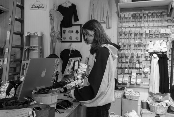 Young shopper browsing accessories at a pawn or thrift shop counter