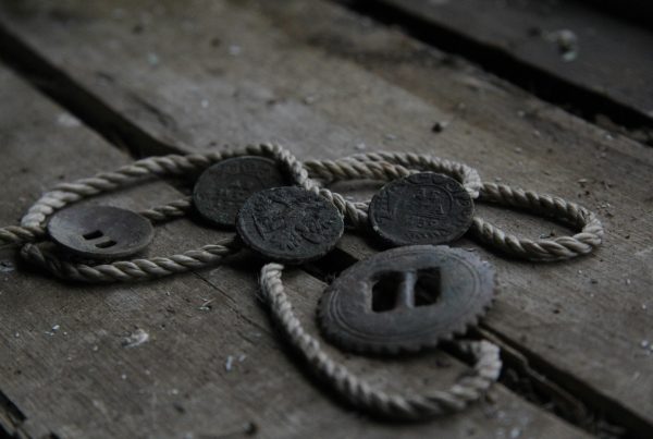 Vintage coins tied with rope on rustic wooden floor, symbolizing pawn shop appraisal and value