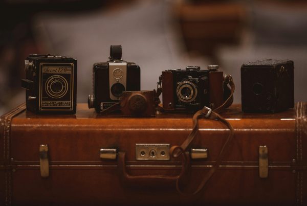 Vintage cameras displayed on a leather suitcase, symbolizing a community pawn shop's cultural and historical value