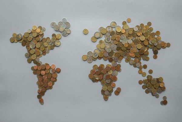 World map creatively illustrated with collectible coins representing global currency investment opportunities